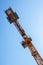 Crane detail against a blue sky, orange metal construction and c