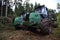 Crane forwarder machines at during clearing of a plantation. Wheeled harvester transports raw timber from the felling site out to