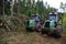 Crane forwarder machines at during clearing of a plantation. Wheeled harvester transports raw timber from the felling site out to