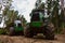 Crane forwarder machines at during clearing of a plantation. Wheeled harvester transports raw timber from the felling site out to