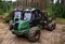 Crane forwarder machines at during clearing of a plantation. Wheeled harvester transports raw timber from the felling site out to