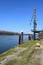 crane at harbor pylons in front of a bridge