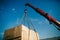 Crane lifts heavy container on a truck