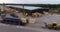 Crane loads a wooden beam in a container, active work of heavy machinery in the yard of the sawmill