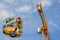 Crane machine in the sand - construction works on the street. Construction tower crane against the sky - collage