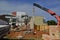 Crane. Masons on construction site with ladder working on construction in placing pre-molded concrete beam for concrete wall in Br