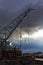 Crane at the shipyard against a background of evening storm clouds.