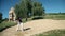 Crane shot of the idyllic golf sand course with a man golfer that plays golf and