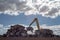 Crane stacking cubes of compressed metal at recycling center