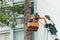 Crane truck on road for group of people working in Saigon,Vietnam, Vietnamese worker work on boom lift to cut branch of tree for