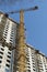 Crane works in building construction against blue sky