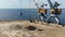 Cranes with buckets moving rubble from a barge on water at docks.