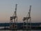 Cranes and containers in shipyard at dusk