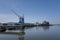 Cranes near the river against blue sky. Industrial landscape, industrial zone