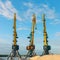 Cranes near the sand against a blue sky. Industrial landscape, industrial zone