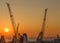 Cranes in shipyards in the port of Genoa at sunset, Italy.