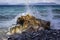 A crashing wave on a volcanic rock creates beautiful splashes!