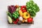 Crate with different fresh vegetables on light background