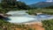 In the crater of an extinct volcano there is a geothermal lake with blue opaque water.