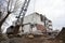 Crawler crane with a heavy metal wrecking ball on a steel cable at demolition of tall building. Wrecking ball for demolish.