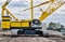 Crawler crane isolated front view on a construction site with focus on the machine deck.