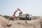 crawler excavator and a construction dump truck standing side by side while working on a construction site