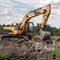 Crawler excavator digs the earth with a bucket. Drainage of swamps. Clearing the construction site.