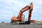 Crawler excavator with hydraulic hammer for the destruction of concrete and hard rock at the construction site.