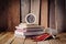 Crayons stack of books and clock on desk a wooden floor