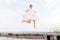 The crazy bride jumps and hangs in the sky against the backdrop of the cityscape of a small resort town in the northern