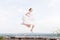 The crazy bride jumps and hangs in the sky against the backdrop of the cityscape of a small resort town in the northern