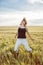 Crazy caucasian woman is jumping in the wheat field, beauty and