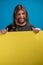 Crazy funny adult male portrait making grimace while holding a yellow advertise banner