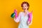 Crazy girl use chemical spray bottle show horned symbol wear bath robe gloves isolated yellow color background