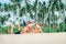 Crazy happy father and son lie on tropical sand beach in Sants h