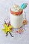 Crazy milk shake with whipped cream and colored sprinkles in glass jar