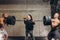 Crazy obese girl having breakfast while two sportsmen holding barbell