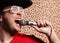 Crazy rock and roller singer with a big black hat, party glasses in front of a cheetah skin background