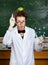 Crazy scientist with an apple on his head shows forefinger while handing molecular model