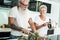 Crazy senior couple cooking together at home - Joyful elderly lifestyle and food nutrition concept - Main focus on woman face