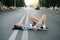 Crazy woman lying on an asphalt road, laughing about situatuon. Side view.