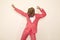 Crazy young guy wearing pink suit and funny dinosaur mask dancing and having fun at party