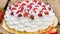 Cream cake with strawberries on wooden table