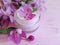 Cream container cosmetic, fresh moisturizing beauty magnolia flower on a pink wooden background