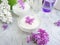 Cream cosmetic flower lilac clean concept freshness on a gray concrete background, extract