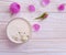 cream cosmetic gypsophila  sensitive rose flower on wooden background