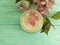 Cream cosmetic pink flowers on mint wood product scrub, handmade