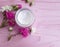 Cream cosmetic rose flower essence freshness relaxation ointment on a pink wooden background