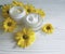 Cream cosmetic yellow daisy flowers handmade container beautiful relaxation on a white wooden background