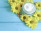 Cream cosmetic yellow flowers. protection capsule blue wooden background